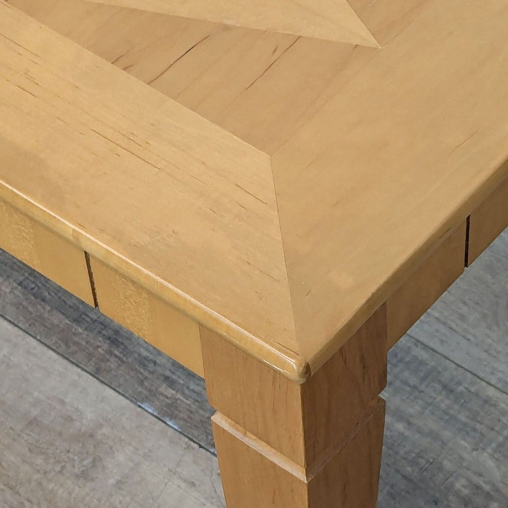 3. Corner detail of Reperch console table highlighting beveled edges and wood texture on leg and top.
