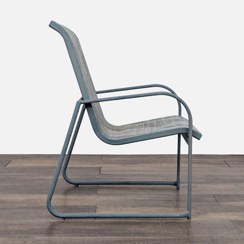 Side profile of a Reperch brand metal chair, showcasing its mesh seat, back, and sleek curved arms.  