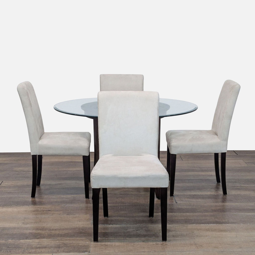 1. Crate & Barrel dining set with round glass table, wood base, and four cream upholstered Lowe chairs.