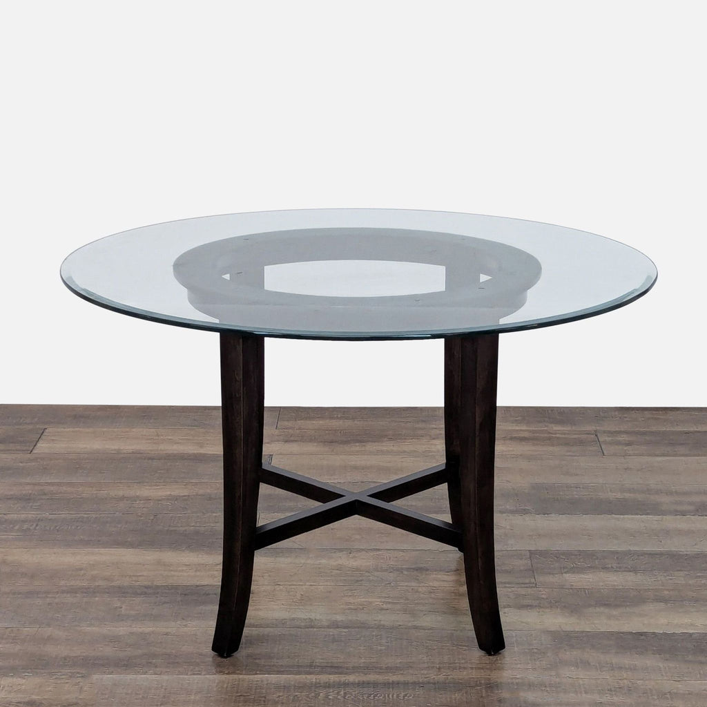 2. Round Crate & Barrel glass dining table with reverse bevel and dark wood cross-base, no chairs pictured.