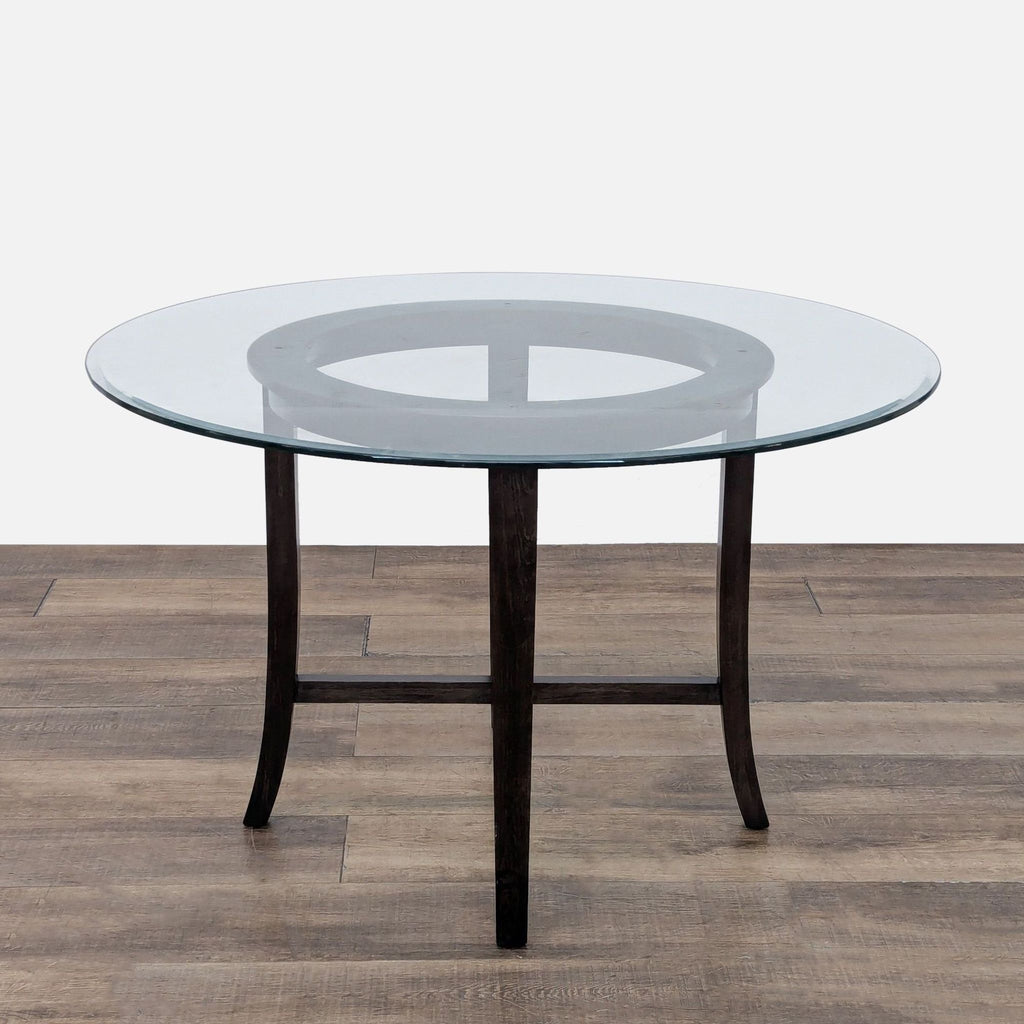 3. Glass top dining table by Crate & Barrel shown alone, featuring a round beveled edge and curved wood legs.