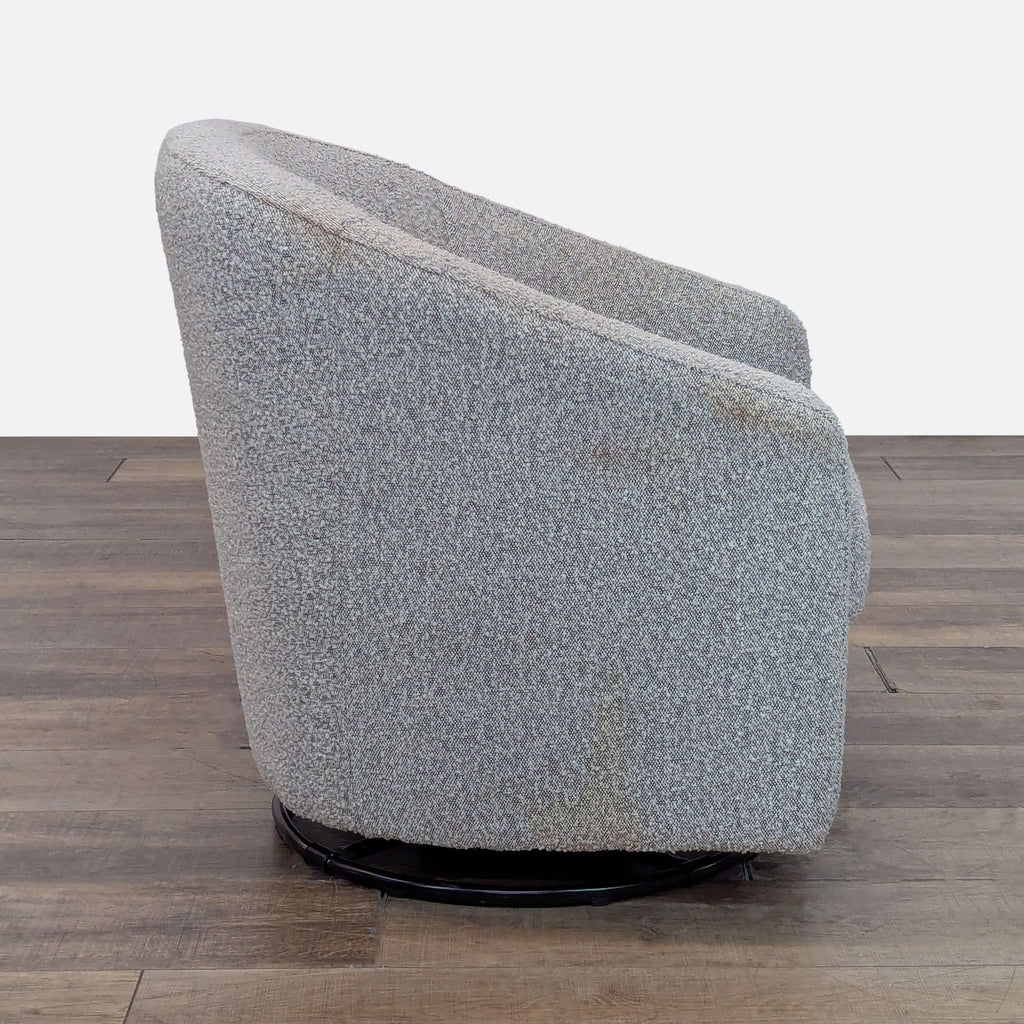 Side profile of the Reperch Lounge swivel chair with curved bouclé upholstery and visible metal base.  