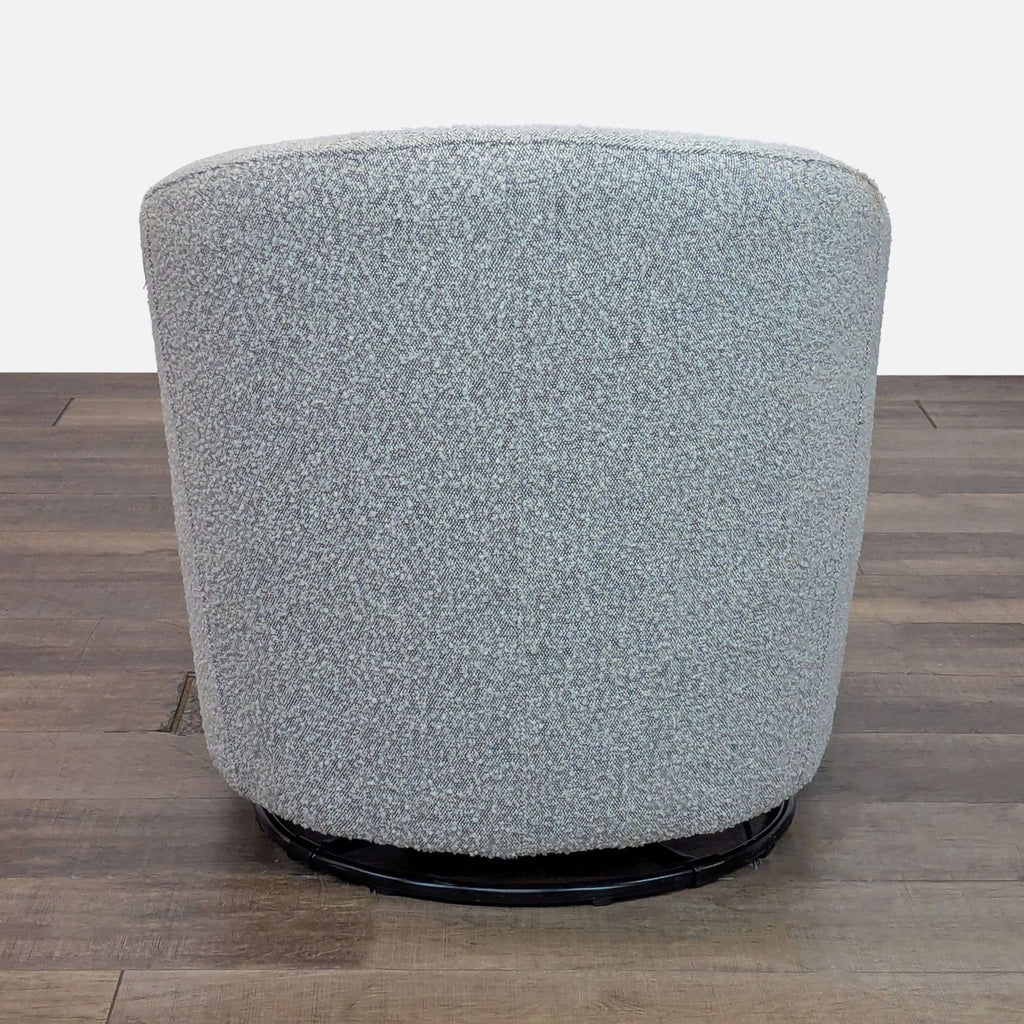 Rear angle of the Reperch Lounge chair showing full rounded back with bouclé fabric and circular swivel base.