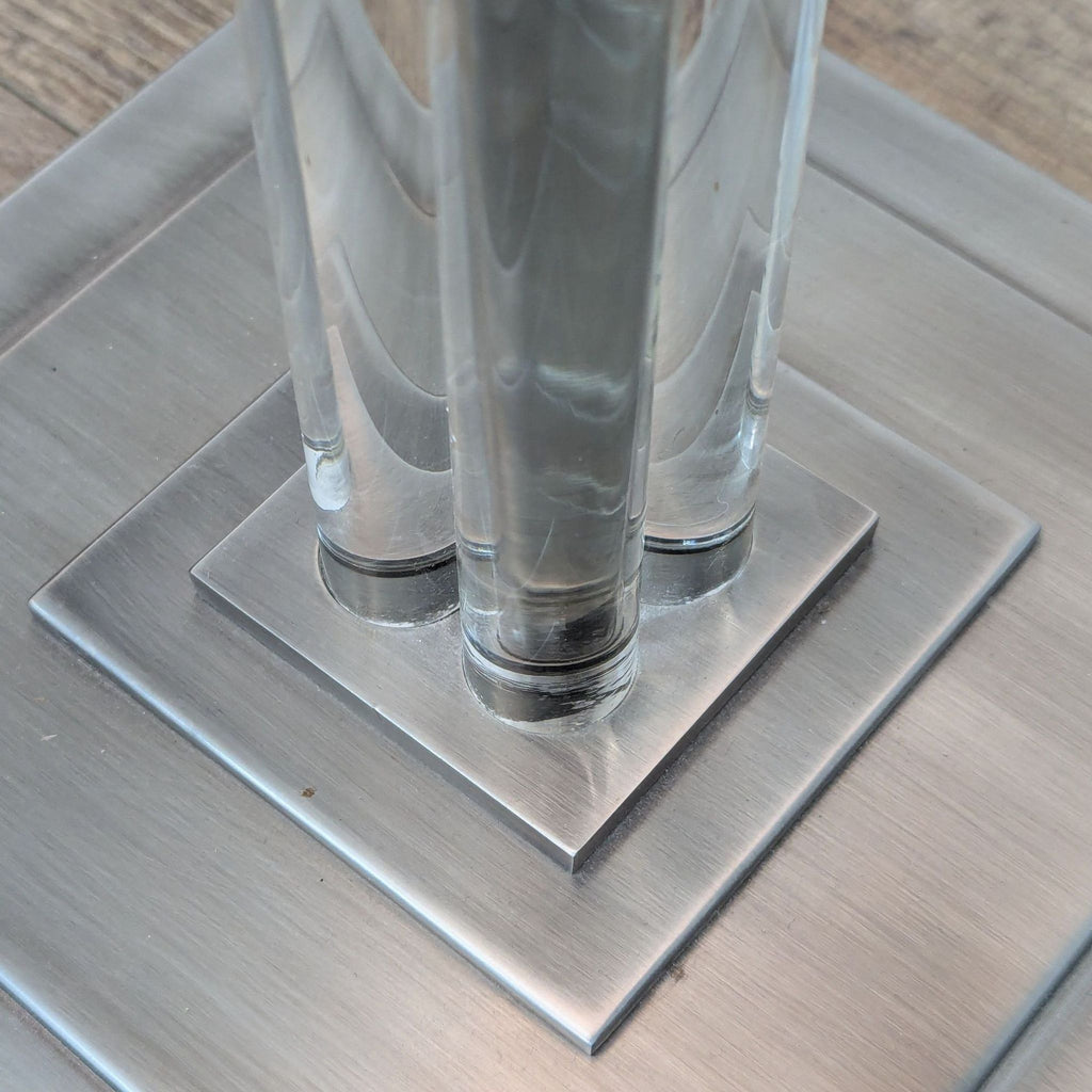 2. Close-up of chrome base with four clear columns from a Restoration Hardware floor lamp in the lighting category.