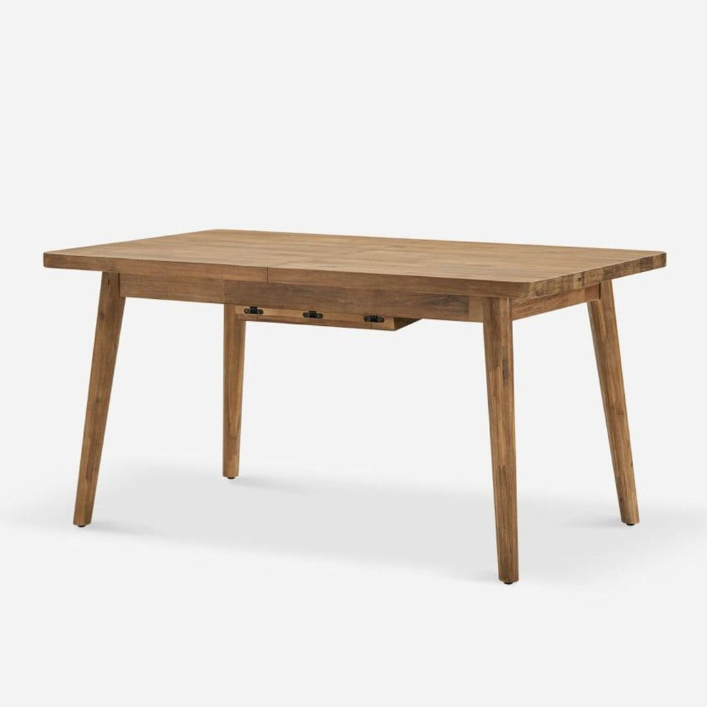 3. Angled view of Castlery dining table, solid acacia with a muted honey finish and mid-century modern legs.