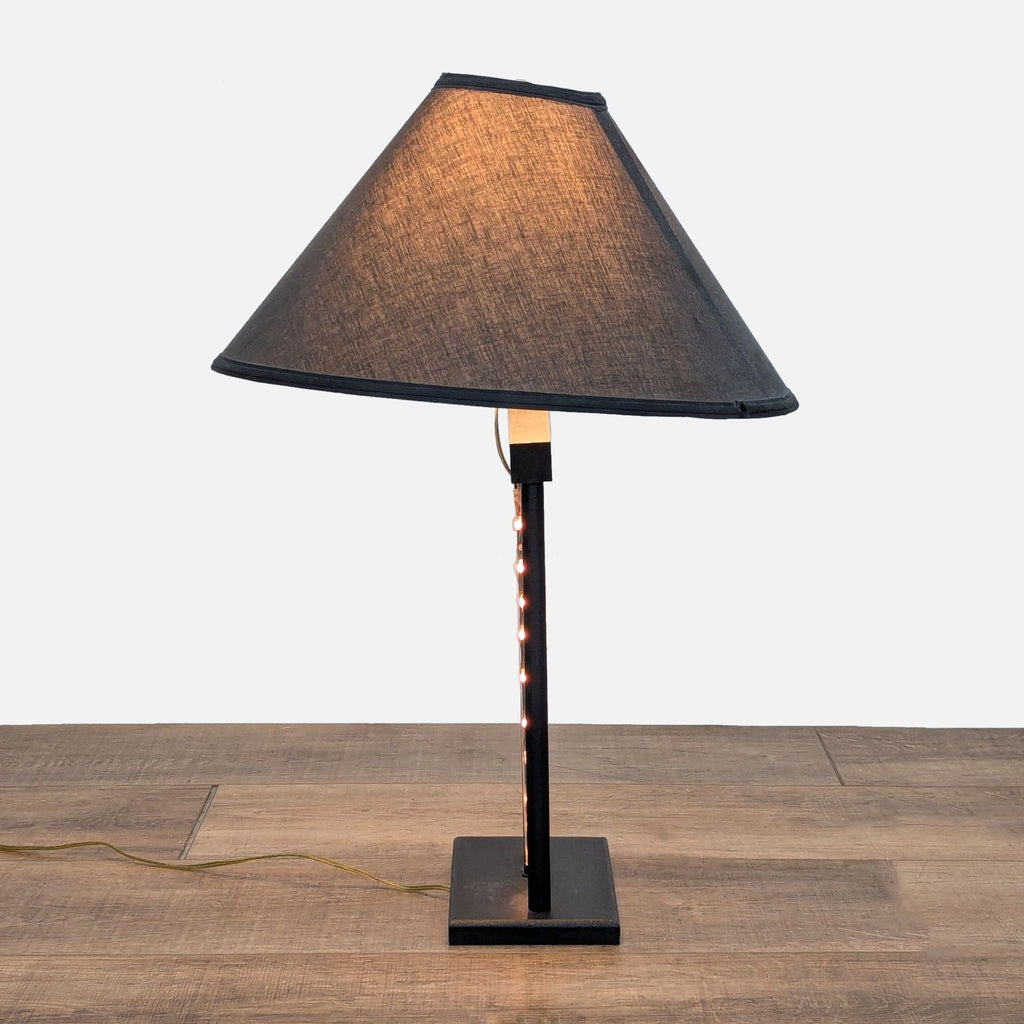 3. Side view of Reperch lamp, featuring rope light going up the center stem beneath a dark lampshade.