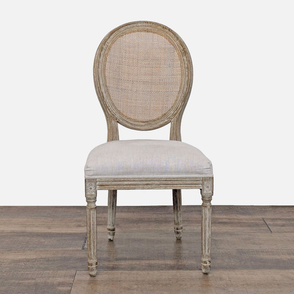 Front view of a Restoration Hardware neoclassic dining chair with a hand-carved oak frame and linen seat.