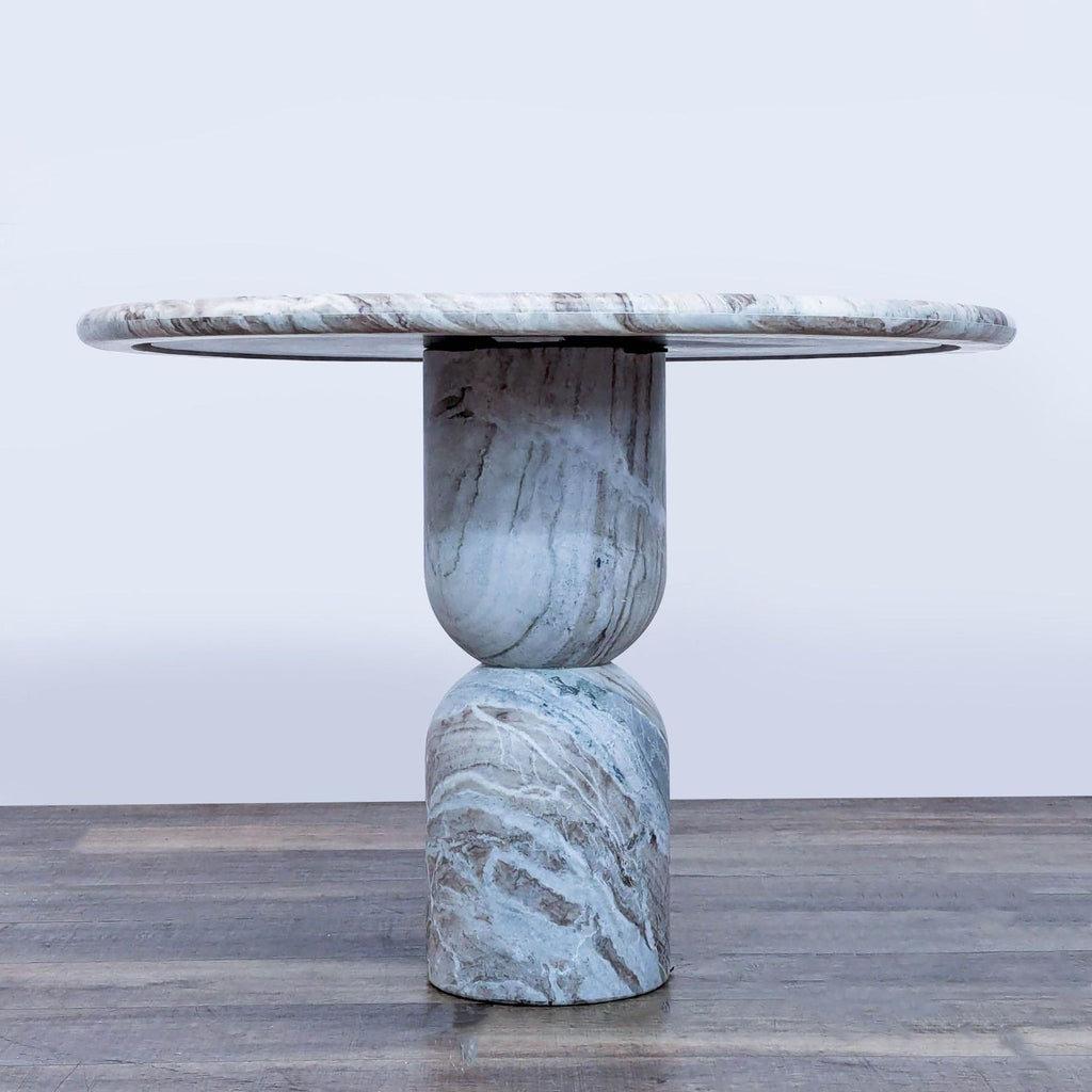 2. Side view of marble dining table with a rounded top and artistic pedestal base from Amber Interiors/Four Hands.  