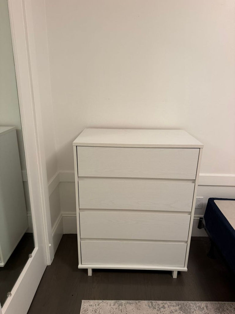 1. Modern white four-drawer dresser from Target, placed against a wall in a bedroom corner.