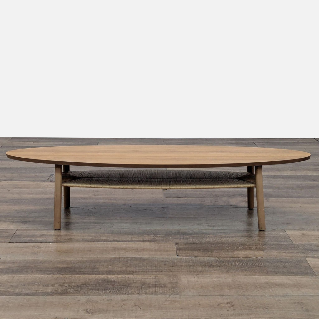 1. Reperch Mid-Century coffee table with oval wood top and raffia-covered shelf, viewed from the front.