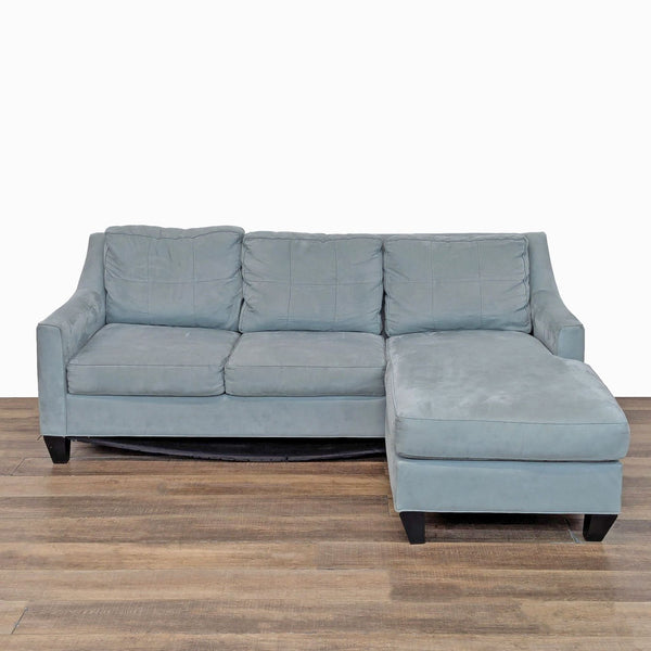 1. Light blue Cindy Crawford Home sectional with tufted back cushions, sloped arms, and wood feet, front view.  