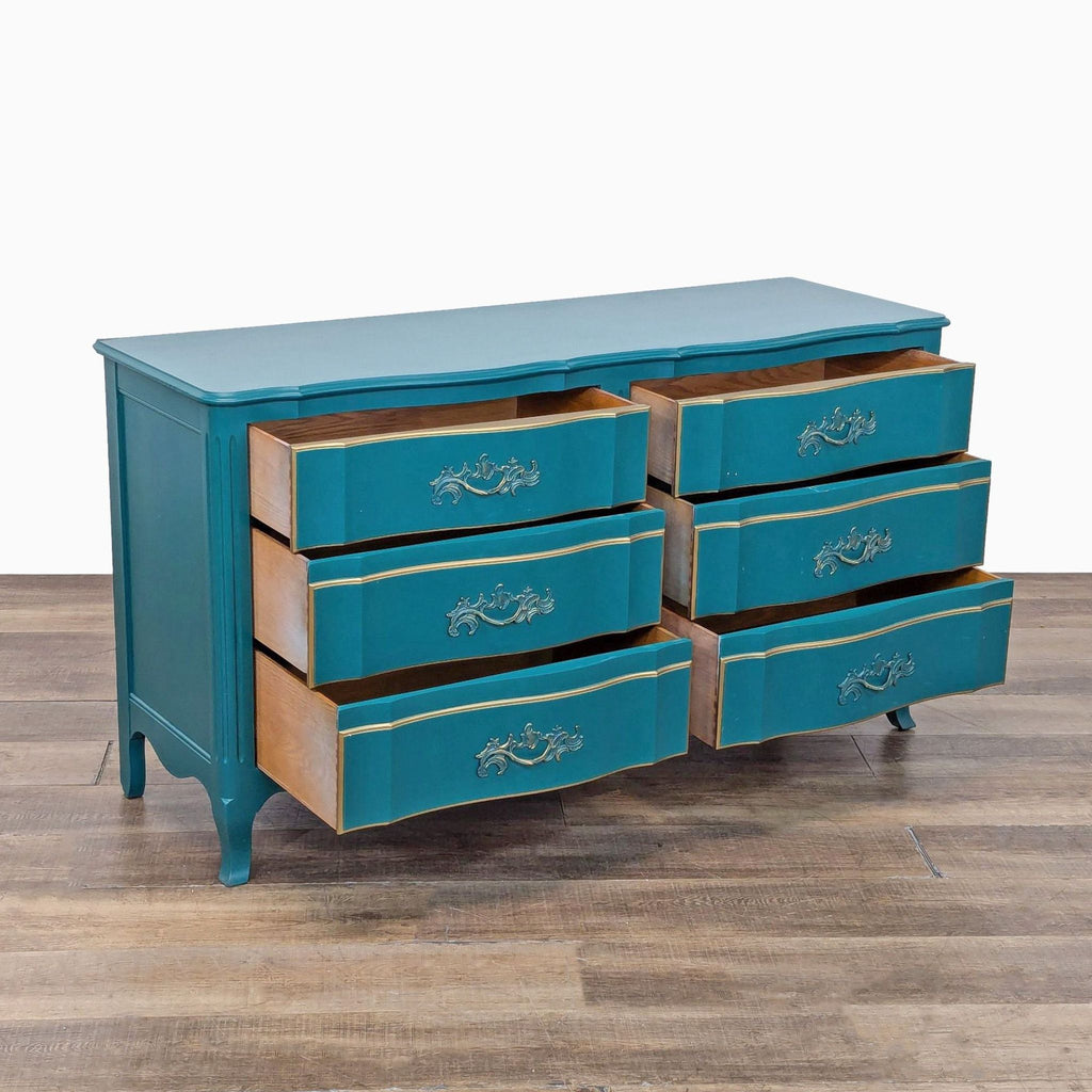 Side view of a vintage John Widdicomb Co. dresser in teal with carved legs and gold accents, solid wood construction.