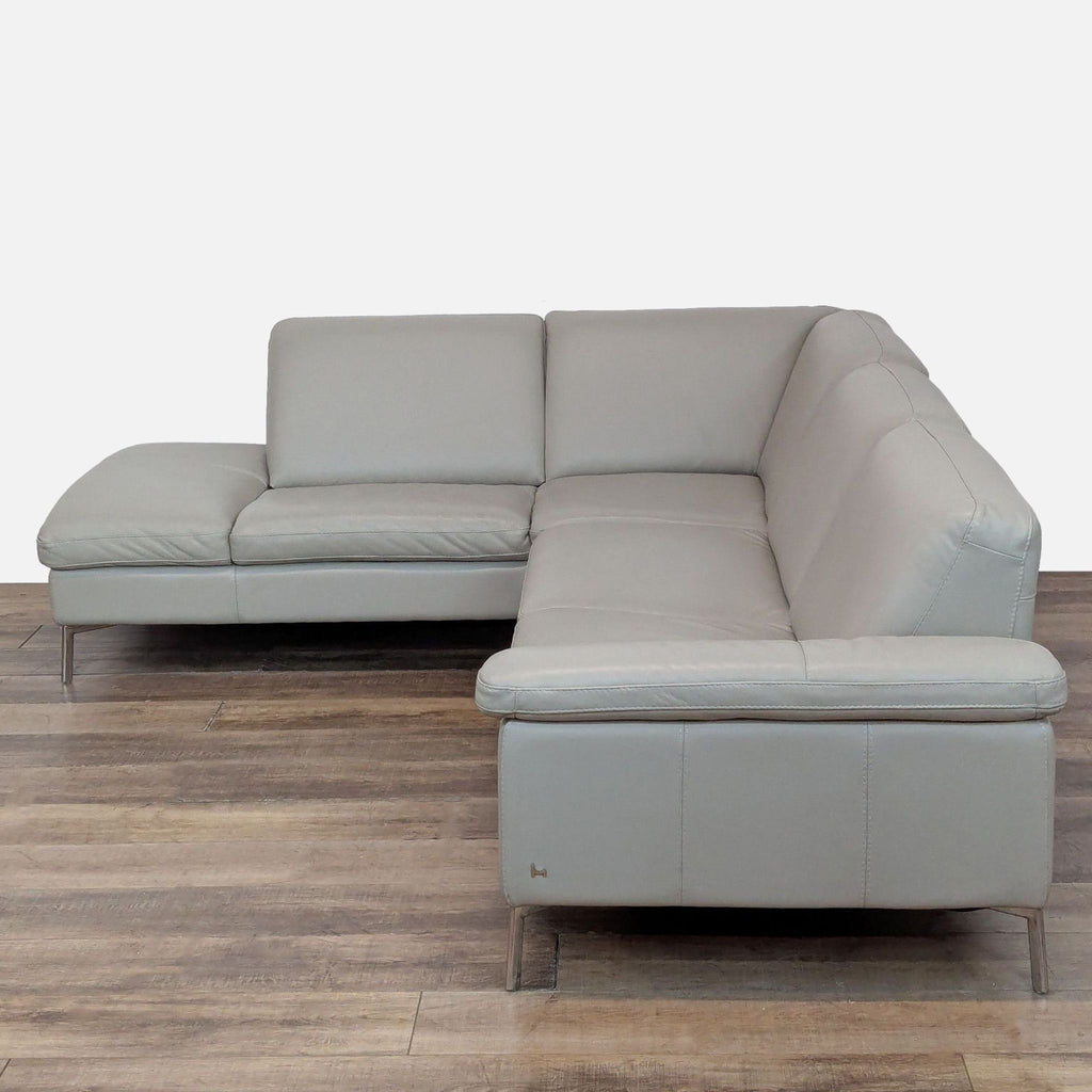 3. Angled view of the Nicoletti sectional with clean leather surfaces and sturdy stainless steel legs.