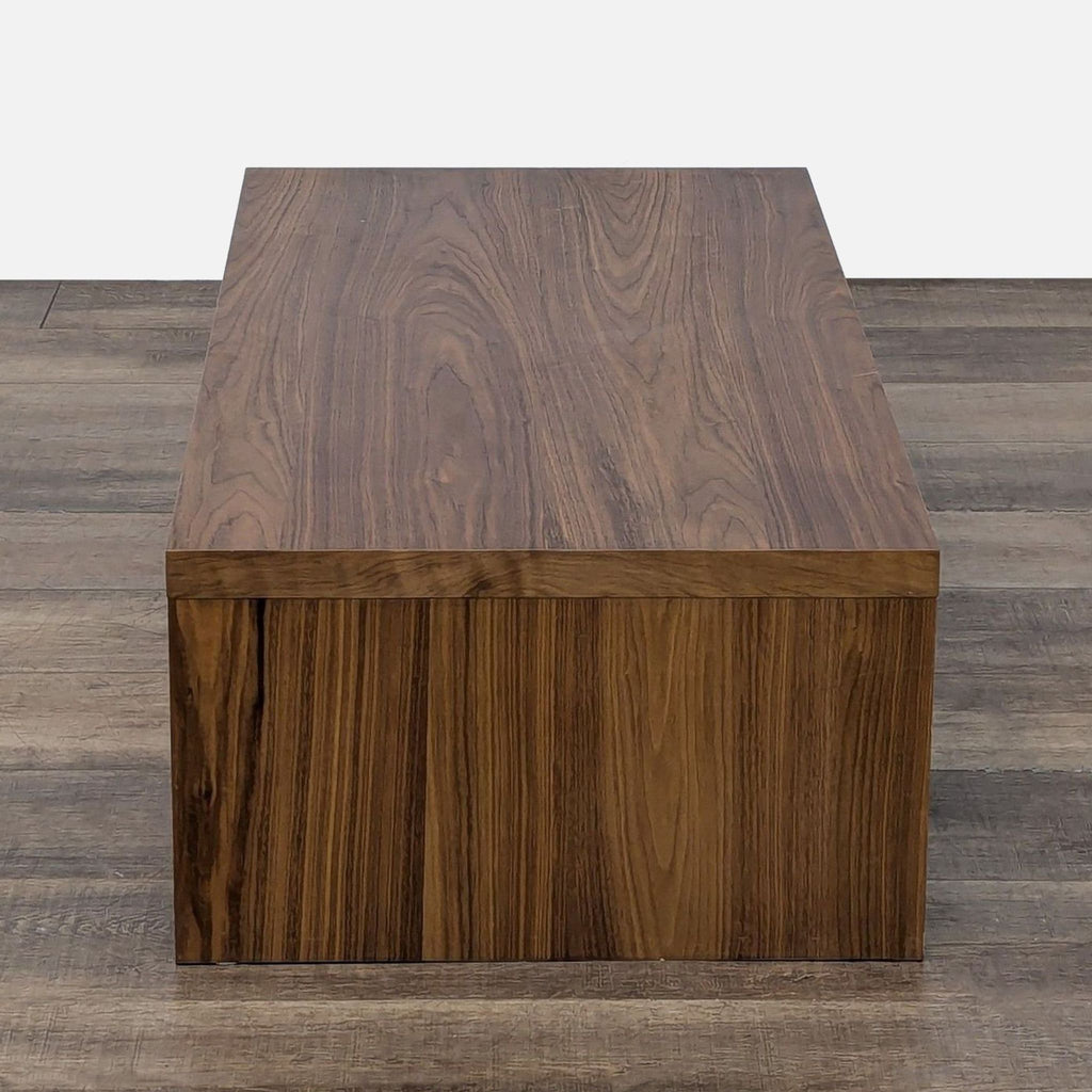 3. End view of the West Elm coffee table, highlighting its solid rectangular shape and wood texture.
