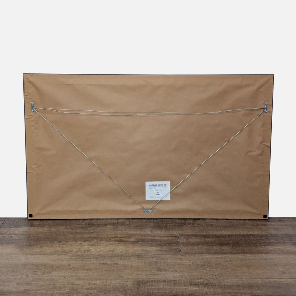 3. Backside of framed artwork with hanging wire and maker’s label displayed.