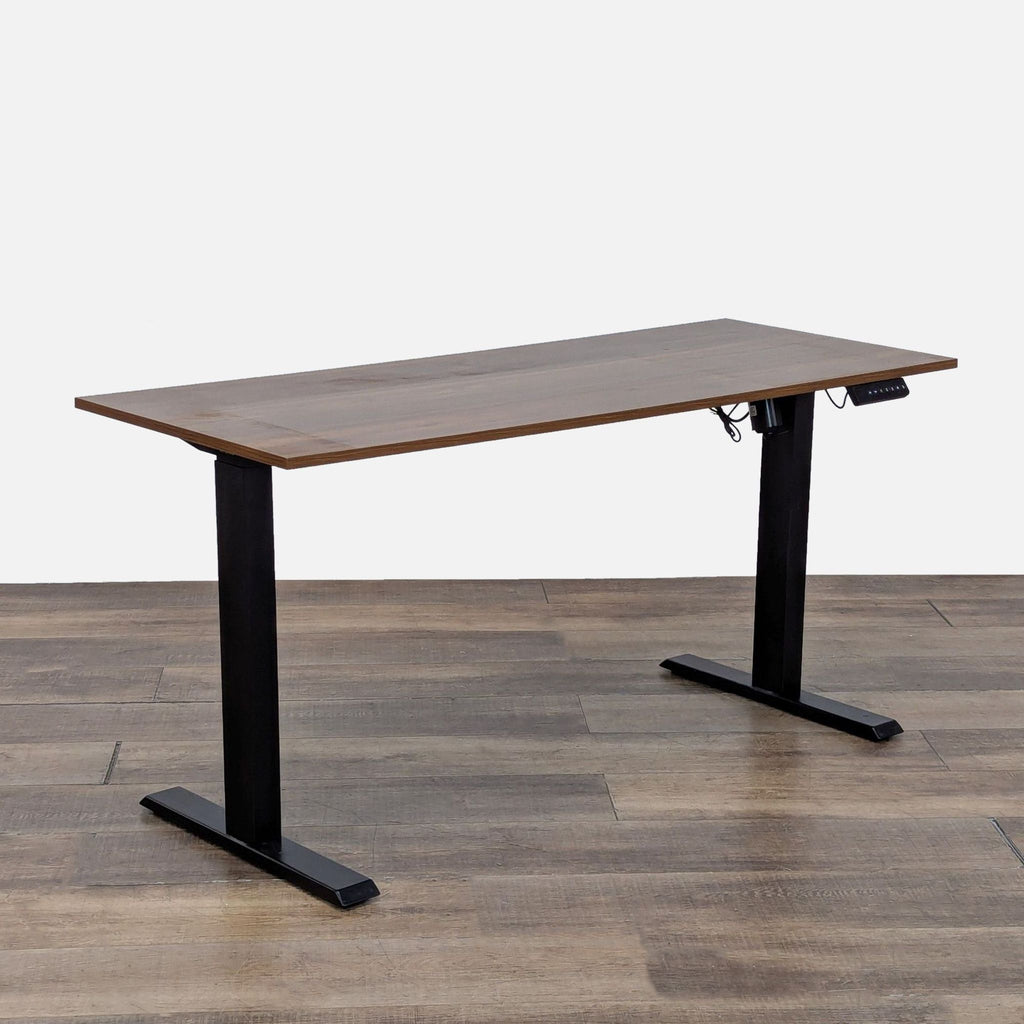 Angled view of Reperch standing desk with height adjustment controls, wood grain top, and black metal frame.