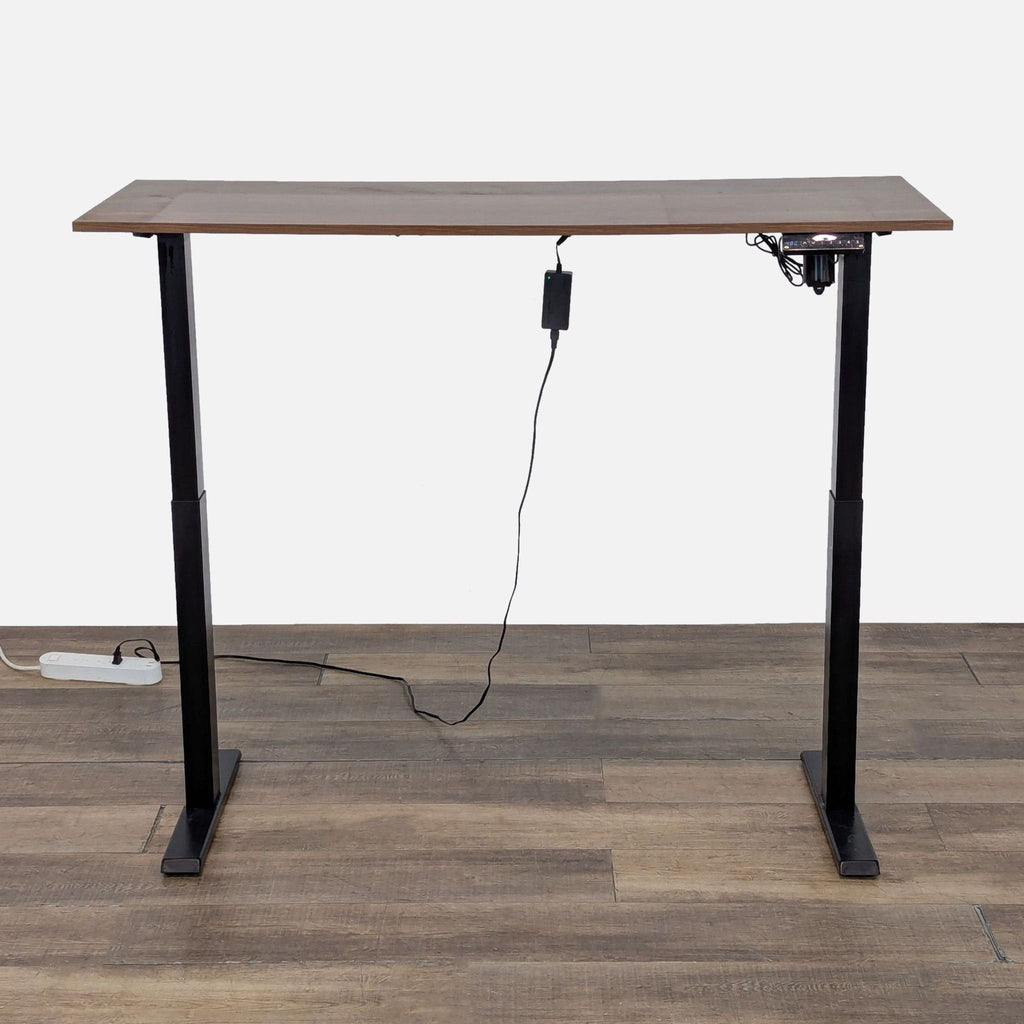 Reperch programmable standing desk shown elevated, featuring a wood grain laminate top and black metal legs.