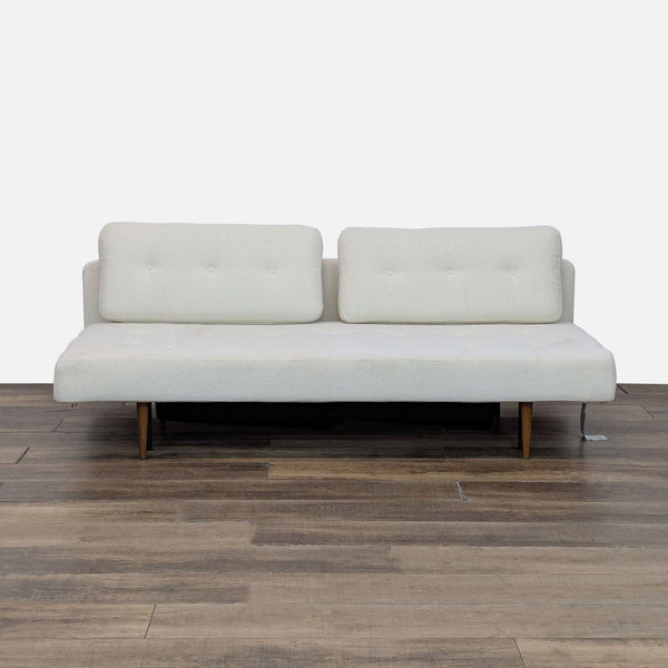 1. Modern Room & Board sleeper sofa with button tufting and under-seat storage on wooden floor.