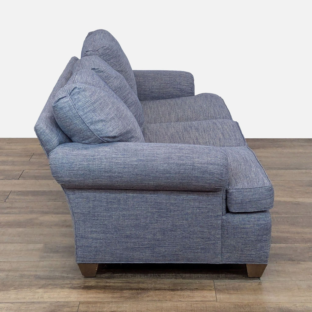Side view of a Reperch 3-seat sofa, showing its heathered blue upholstery and rolled arm design.