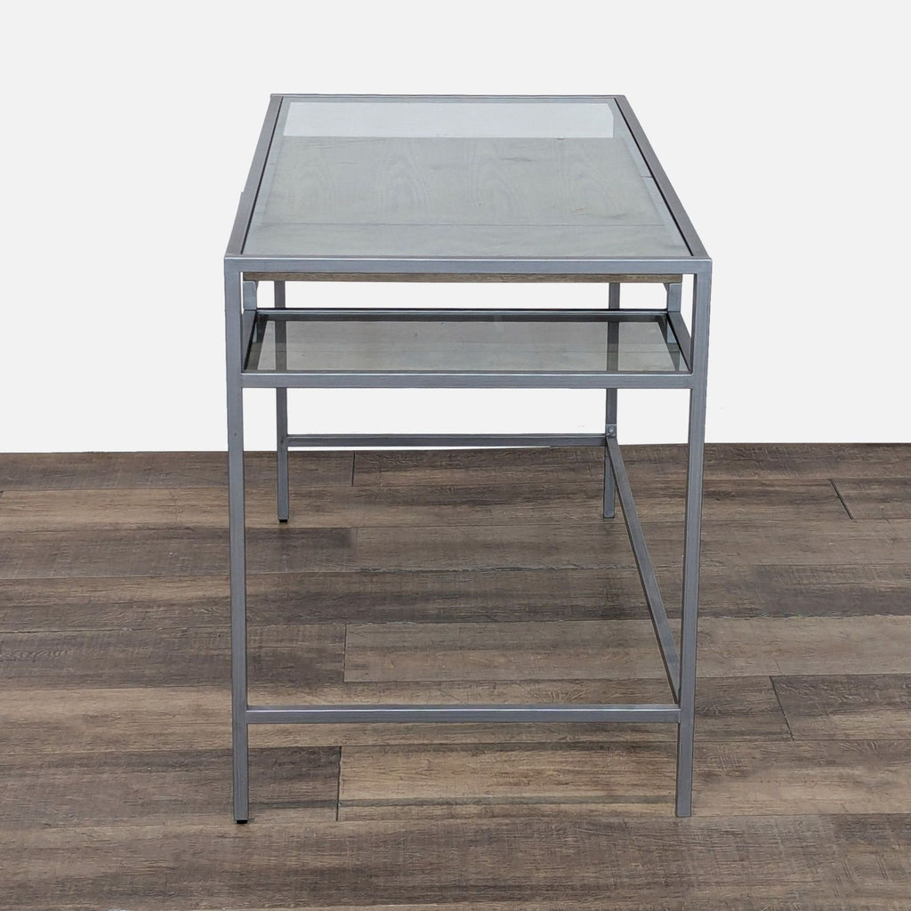 2. Side view of glass-top Madison Park desk, showing metal frame and lower glass shelf structure.