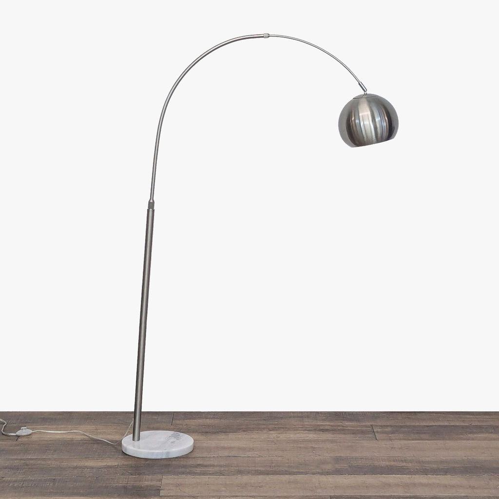 2. Reperch arc floor lamp with a sweeping curved arm, brushed metal lampshade, and circular marble base on wood floor.  