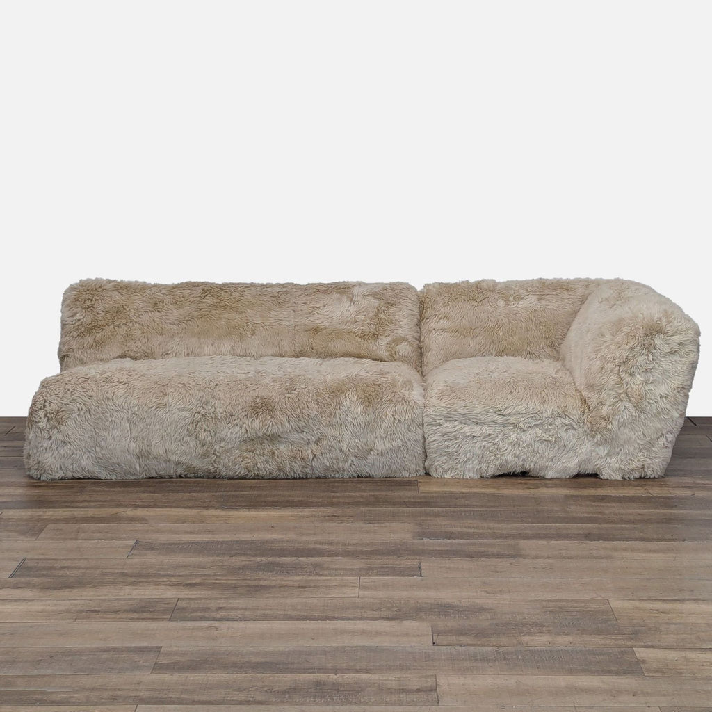 1. Front view of a Restoration Hardware sectional with plush, natural New Zealand sheepskin upholstery.