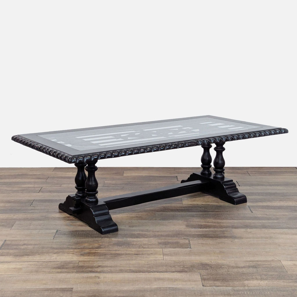 3. Angled view of black Reperch hand-carved dining table with intricate ironwork under a glass surface.