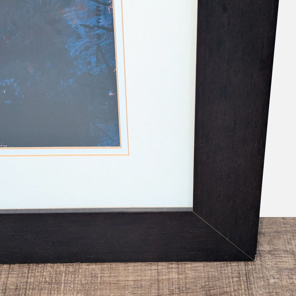 3. Detailed view of the dark wood frame and matting surrounding a cityscape print by Marti Bofarull.