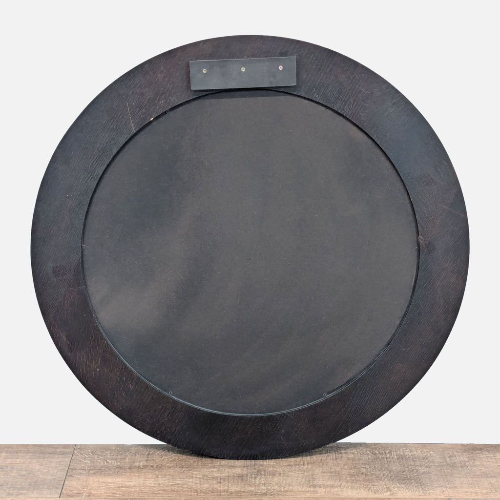 2. Back view of a circular Crate and Barrel mirror with a dark wood frame and mounting hardware visible.