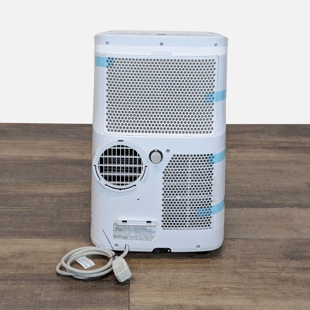 Rear view of Toshiba portable air conditioner showing vent, filter grilles, and attached power cord for easy setup.
