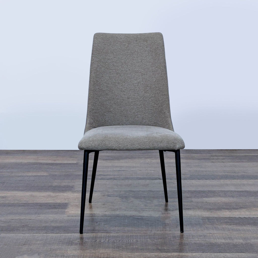 1. Front view of an Interial dining chair with fabric seat, faux leather backrest, and steel legs on wood floor.