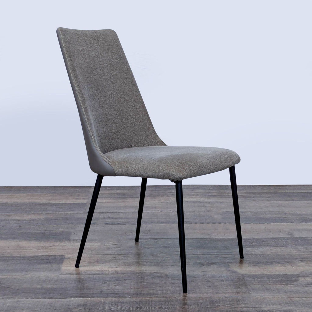 2. Angled side view of an Interial dining chair, featuring breathable fabric and sleek steel legs.