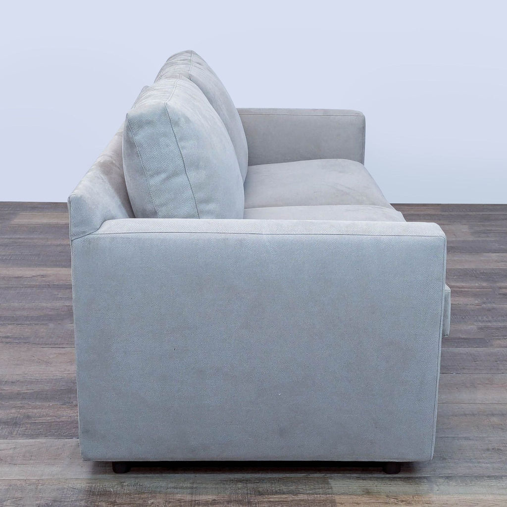 2. Side view showing the clean lines of a Restoration Hardware sleeper loveseat in light gray upholstery.