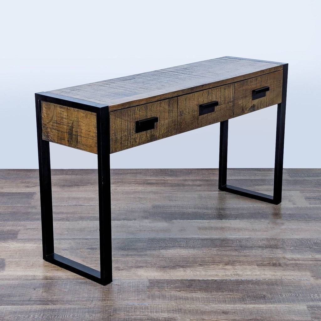 3. Side table by Reperch features rustic wood, industrial metal legs, and three hardware-accented drawers.
