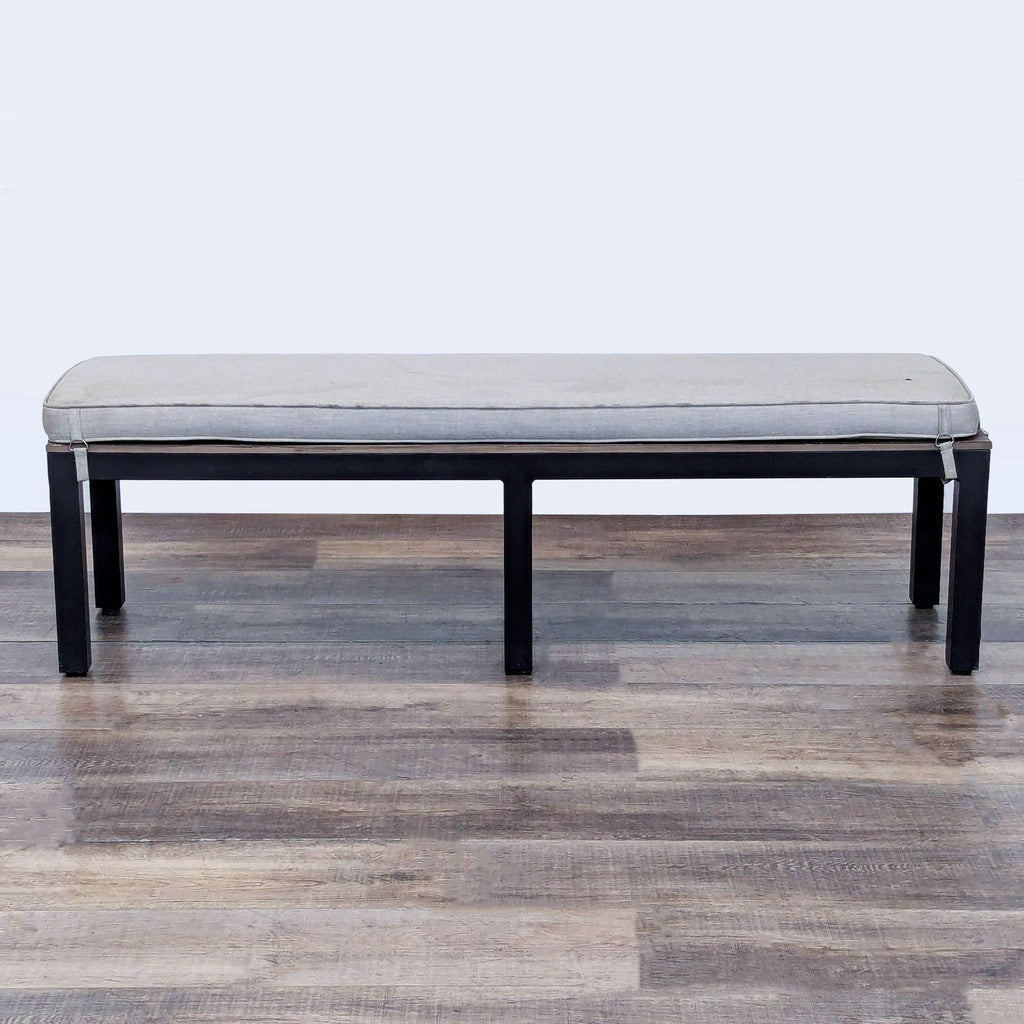 1. Sunbrella aluminum bench with a wood plank top and removable cushion, shown on a wood floor.