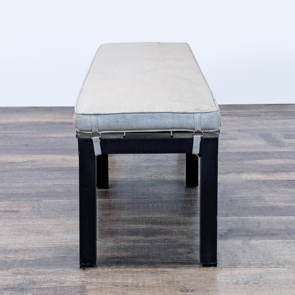 2. End view of a Sunbrella aluminum bench with light cushion and visible cushion straps.