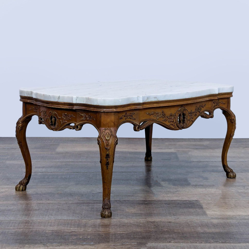 3. Coffee table by Reperch with carved floral motifs, paw-foot cabriole legs, and an elegant marble tabletop.