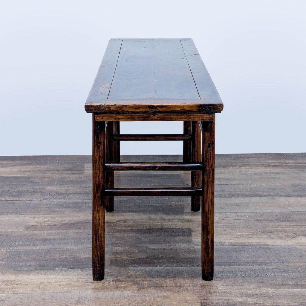 3. Side view of a hand-carved Reperch elmwood console table, highlighting the table’s craftsmanship and finish.