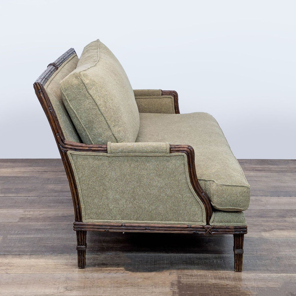 3. Side view of Century loveseat highlighting wooden frame detailing and muted green textured fabric.
