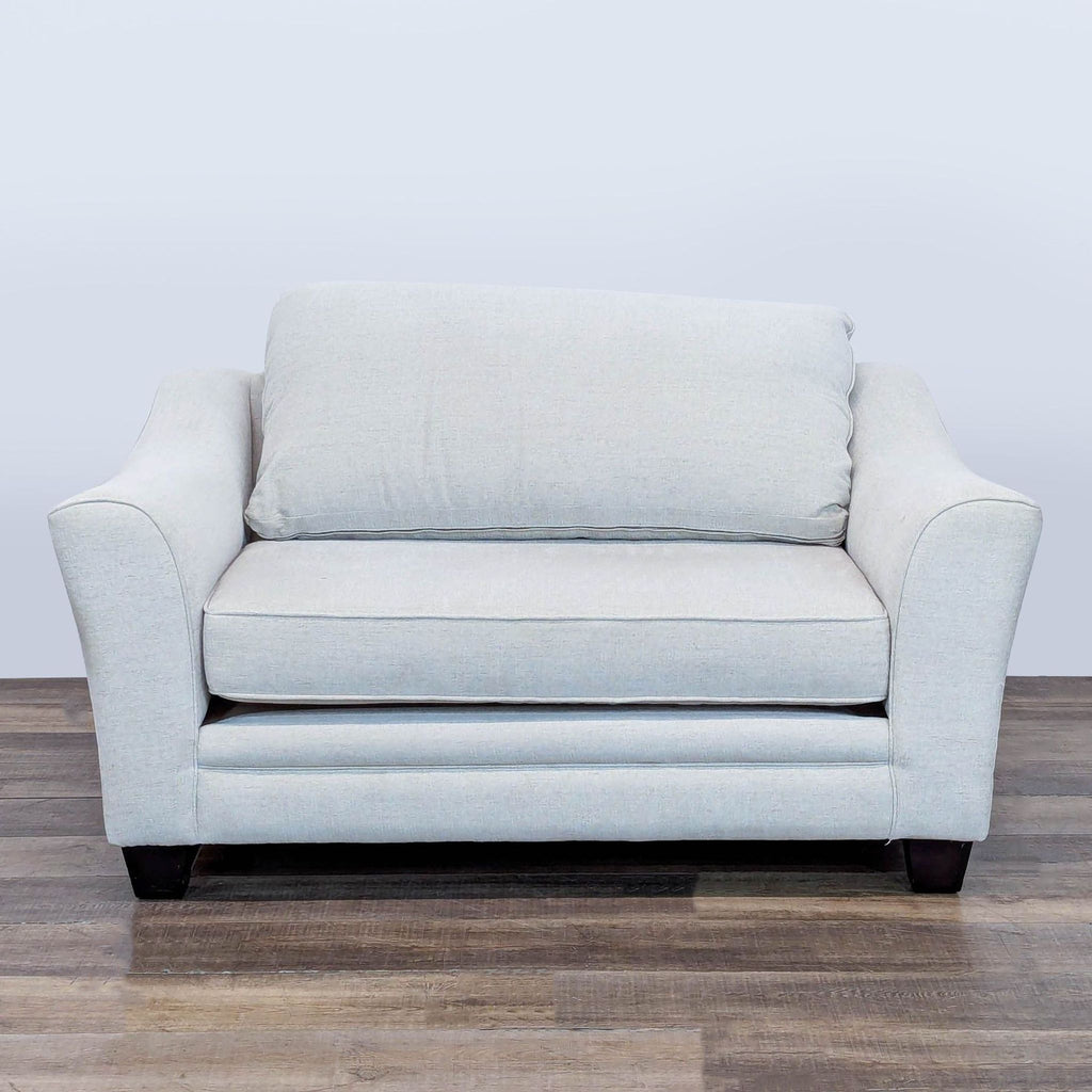 1. Light gray lounge chair with plush removable cushions and dark wood feet, by Living Spaces, front view.