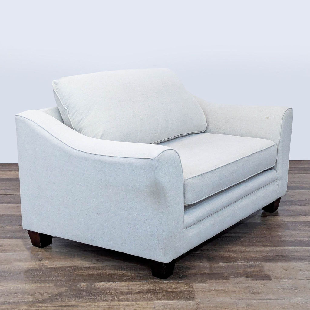 3. Angled view of a Living Spaces lounge chair in light gray, with removable cushions and wood feet, lounge category.
