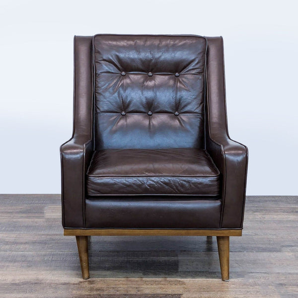 1. Front view of a Reperch lounge chair with brown leather, button tufting, and tapered wood legs.