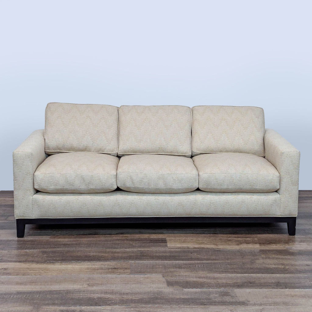 1. Front view of a neutral textured three-seat Holly Hunt/Christian Liaigre sofa with dark-stained wood legs.