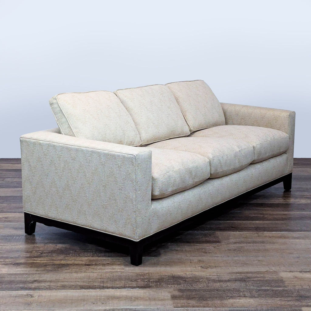 3. Angled view of a modern Holly Hunt/Christian Liaigre three-seater, featuring plush cushions and clean lines.