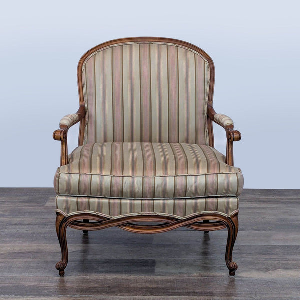 Front view of Ethan Allen lounge chair with carved wood frame and striped upholstery.  