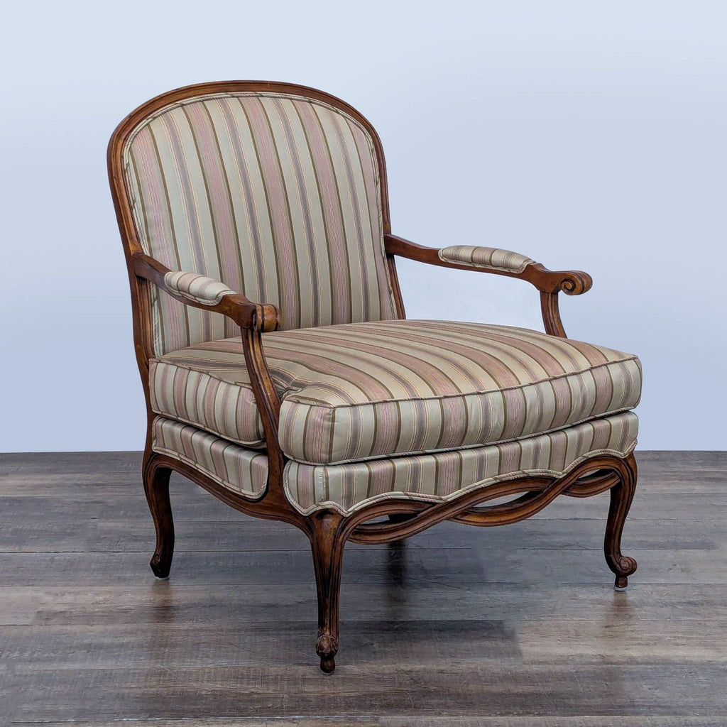 Angled view of Ethan Allen lounge chair, highlighting ornate wood details and striped cushions.
