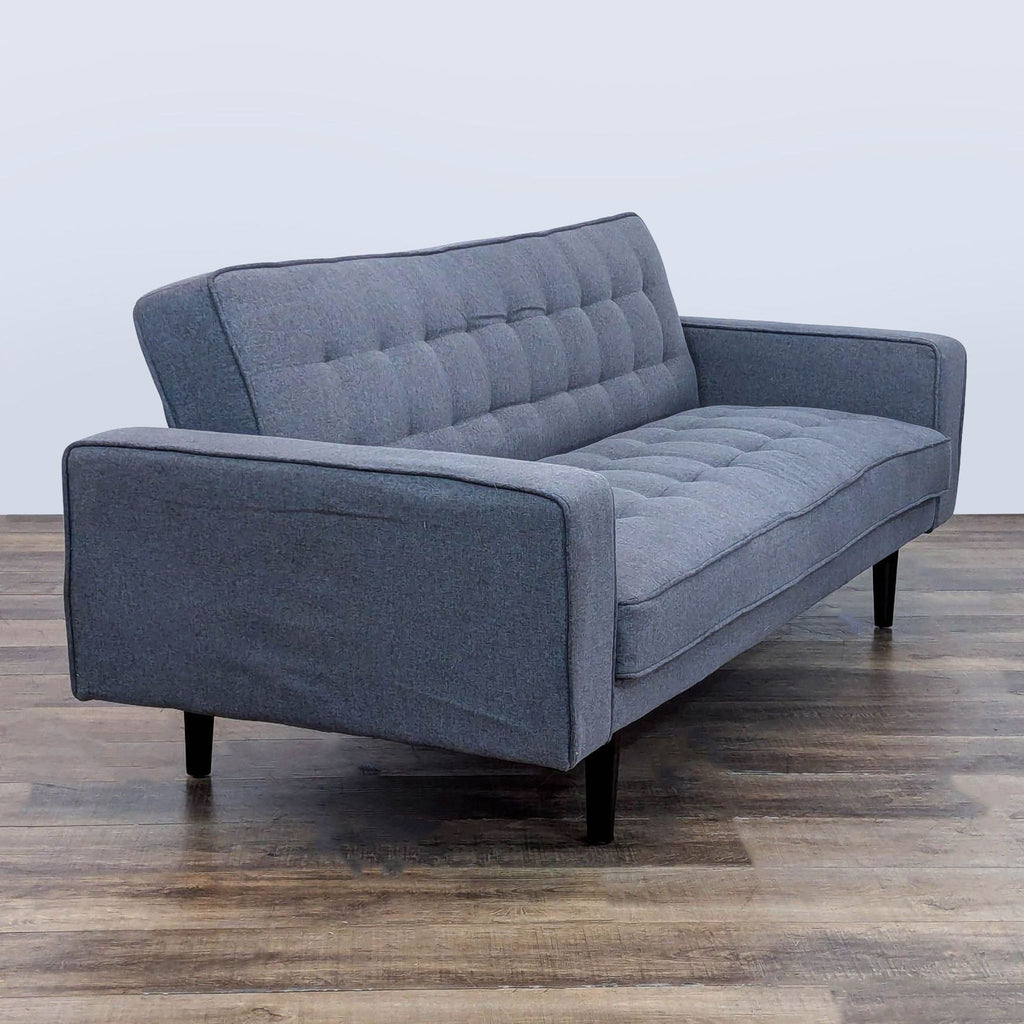 3. Angled view of a Reperch sleeper sofa featuring tufted cushions, track arms, and dark wooden legs.