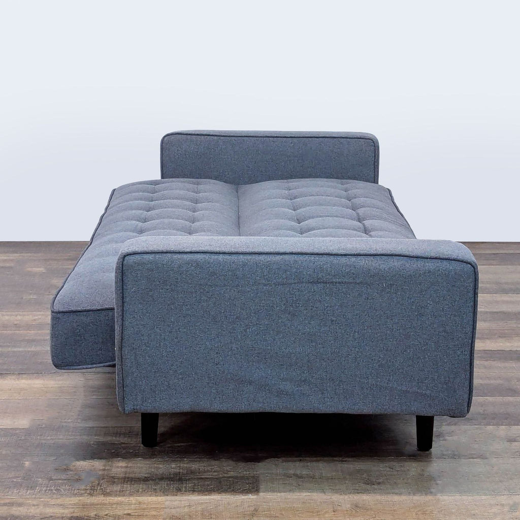 2. Upholstered convertible sleeper sofa by Reperch shown folded out for sleeping, tufted design visible.