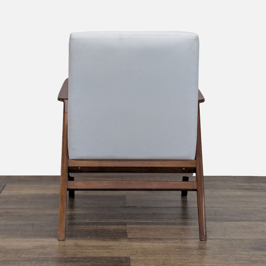 Back view of the Reperch lounge chair showing solid wood angled frame and full upholstered backrest.