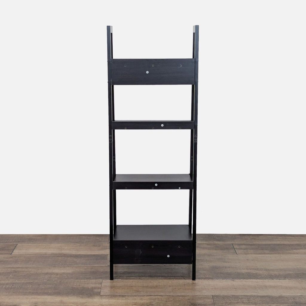 3. Front view of Reperch black wood bookshelf, ladder-style with four fixed shelves on a wood floor.